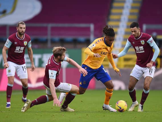 Alex Iwobi of Everton is challenged by Charlie Taylor of Burnley and Dwight McNeil of Burnley during the Premier League match between Burnley and Everton at Turf Moor on December 05, 2020 in Burnley, England.