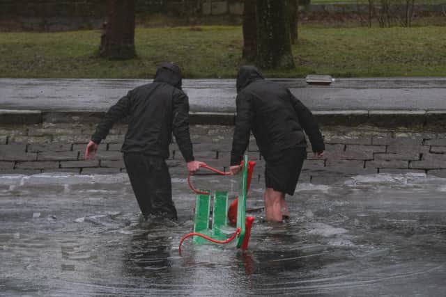 Two of the Northern Monkeys drag one of the dumped benches from the boating lake at Thompson Park in Burnley