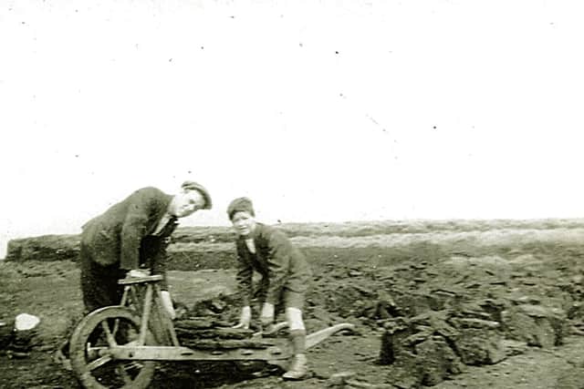 Tom Brennand and his son Steven load their turf barrow on Burn Moor, Clapham cum Newby in the 1920s