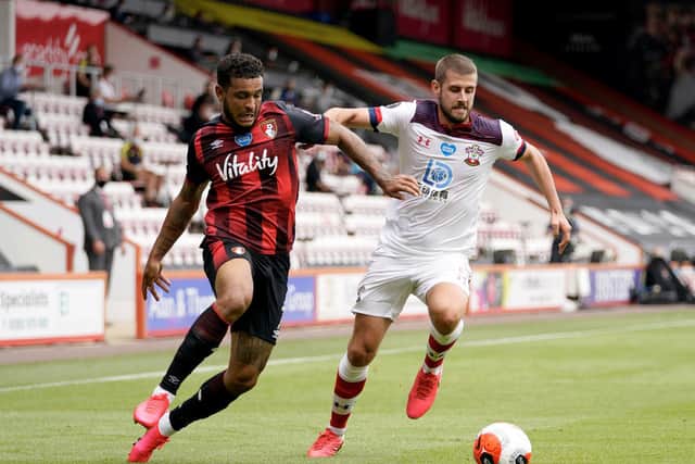 Joshua King of AFC Bournemouth battles for possession with Jack Stephens of Southampton during the Premier League match between AFC Bournemouth and Southampton FC at Vitality Stadium on July 19, 2020 in Bournemouth, England.