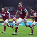 Chris Wood of Burnley celebrates with team mates (L - R) Matthew Lowton and Ashley Westwood after scoring their side's third goal during the Premier League match between Burnley and Aston Villa at Turf Moor on January 27, 2021 in Burnley, England.