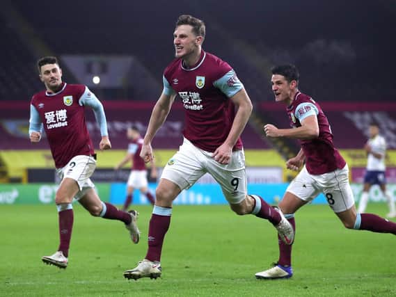 Chris Wood of Burnley celebrates with team mates (L - R) Matthew Lowton and Ashley Westwood after scoring their side's third goal during the Premier League match between Burnley and Aston Villa at Turf Moor on January 27, 2021 in Burnley, England.