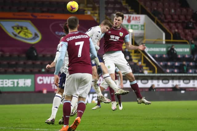 Chris Wood of Burnley scores their side's third goal whilst under pressure from Matt Targett of Aston Villa during the Premier League match between Burnley and Aston Villa at Turf Moor on January 27, 2021 in Burnley, England.