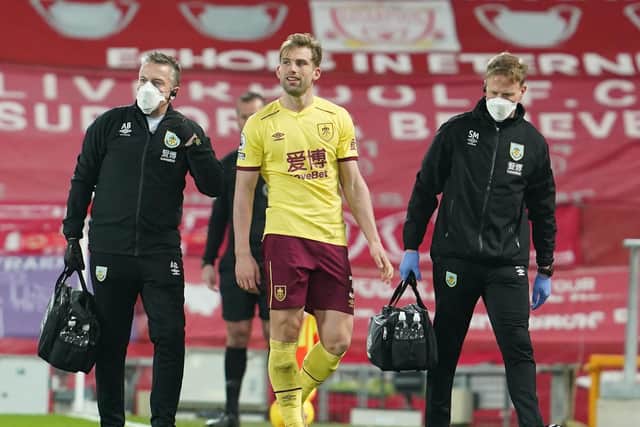 Burnley's English defender Charlie Taylor (C) leaves the field with an injury during the English Premier League football match between Liverpool and Burnley at Anfield in Liverpool, north west England on January 21, 2021.