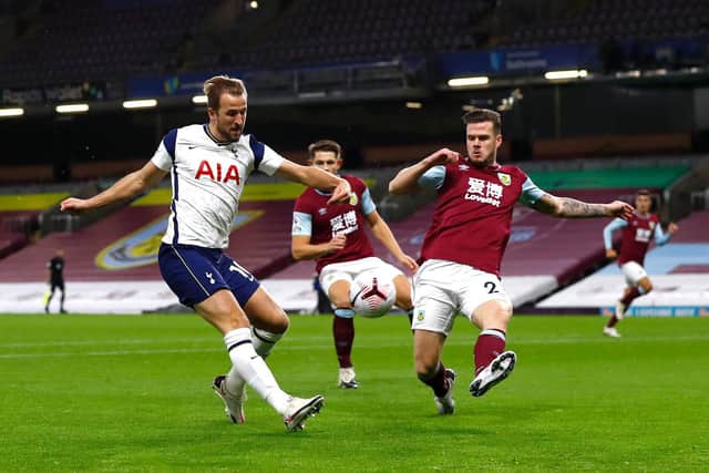 Harry Kane of Tottenham Hotspur shoots under pressure from Kevin Long of Burnley during the Premier League match between Burnley and Tottenham Hotspur at Turf Moor on October 26, 2020 in Burnley, England.