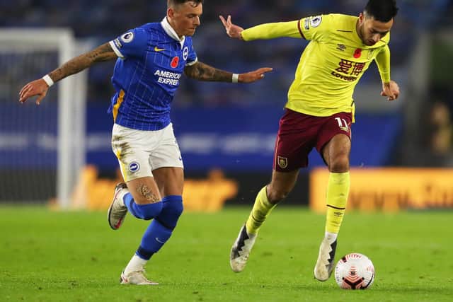 Dwight McNeil of Burnley is challenged by Ben White of Brighton and Hove Albion during the Premier League match between Brighton & Hove Albion and Burnley at American Express Community Stadium on November 06, 2020 in Brighton, England.