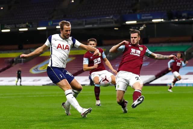 Harry Kane of Tottenham Hotspur shoots under pressure from Kevin Long of Burnley during the Premier League match between Burnley and Tottenham Hotspur at Turf Moor on October 26, 2020 in Burnley, England.