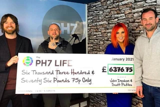 The 'Pendle Hell' challengers John Deehan (left) and Scott Pickles (second left) present a cheque for the money they raised to Rebecca Jane and PH7 Group CEO Paul Howarth.