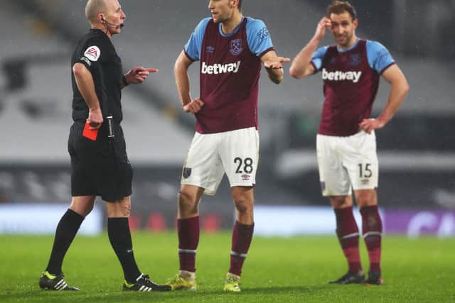 Tomas Soucek of West Ham appeals to match referee Mike Dean after being shown a red card during the Premier League match between Fulham and West Ham United at Craven Cottage on February 06, 2021 in London, England.