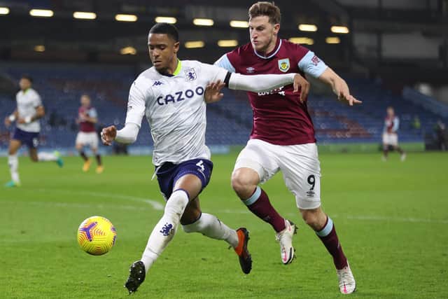 Ezri Konsa of Aston Villa battles for possession with Chris Wood of Burnley during the Premier League match between Burnley and Aston Villa at Turf Moor on January 27, 2021 in Burnley, England.