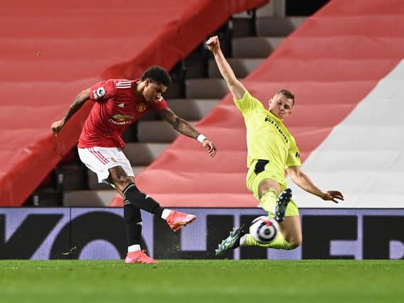 Manchester United's English striker Marcus Rashford (L) shoots to score the opening goal under pressure from Newcastle United's Swedish defender Emil Krafth (R) at Old Trafford in Manchester, north west England, on February 21, 2021.