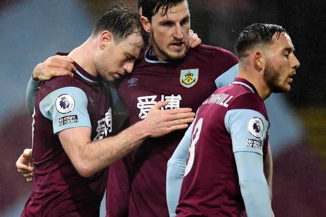 Ashley Barnes of Burnley (L) celebrates with teammates Chris Wood and Josh Brownhill after scoring their team's first goal during the Premier League match between Burnley and Wolverhampton Wanderers at Turf Moor on December 21, 2020 in Burnley, England.