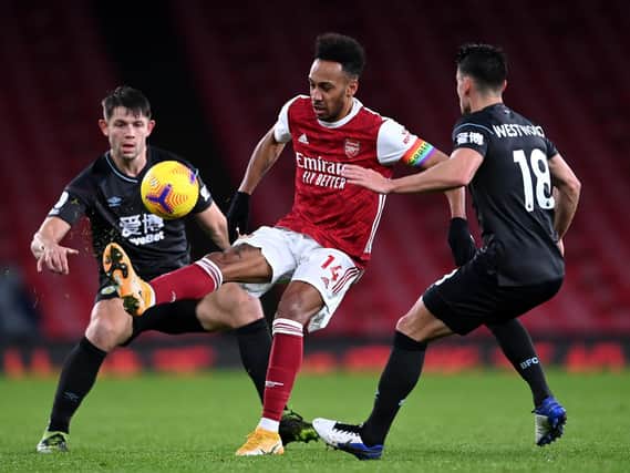 Pierre-Emerick Aubameyang of Arsenal is put under pressure by Ashley Westwood (R) and James Tarkowski of Burnley (L) during the Premier League match between Arsenal and Burnley at Emirates Stadium on December 13, 2020 in London, England.