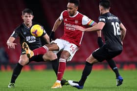 Pierre-Emerick Aubameyang of Arsenal is put under pressure by Ashley Westwood (R) and James Tarkowski of Burnley (L) during the Premier League match between Arsenal and Burnley at Emirates Stadium on December 13, 2020 in London, England.