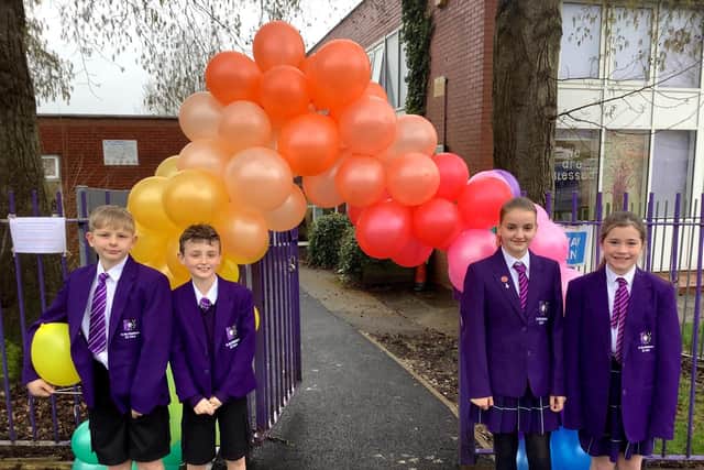 Welcome back! Some of the pupils with the 'welcome back' balloom arch at Burley'sSt Mary Magdalene's RC Primary School