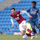 Dwight McNeil of Burnley is challenged by Bukayo Saka of Arsenal during the Premier League match between Burnley and Arsenal at Turf Moor on March 06, 2021 in Burnley, England.