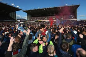 Fans invade the pitch in celebration as Burnley are promoted to the Premier League after the Sky Bet Championship match between Burnley and Queens Park Rangers at Turf Moor on May 2, 2016 in Burnley, United Kingdom. Burnley defeated QPR 1-0 to gain promotion.