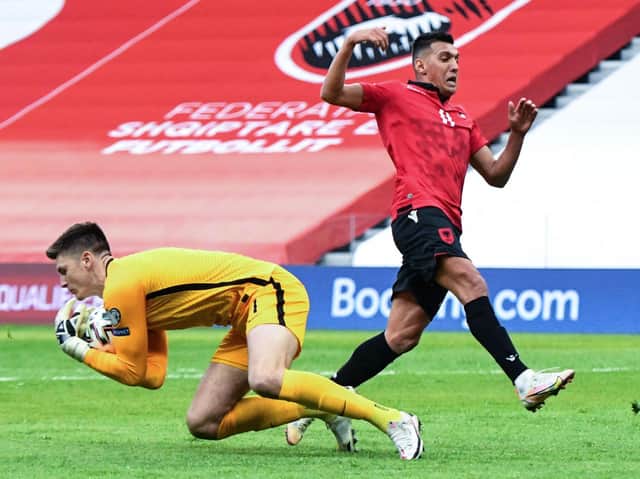 England's goalkeeper Nick Pope (L) catches the ball past Albania's forward Myrto Uzuni during the FIFA World Cup Qatar 2022 qualification Group I football match between Albania and England at the Air Albania Stadium, in Tirana on March 28, 2021.