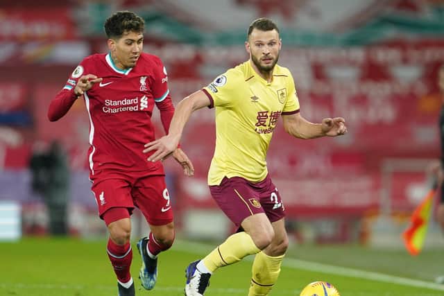 Erik Pieters of Burnley is challenged by Roberto Firminho of Liverpool during the Premier League match between Liverpool and Burnley at Anfield on January 21, 2021 in Liverpool, England.