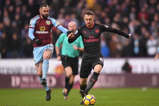 Aaron Ramsey of Arsenal is challenged by Steven Defour of Burnley during the Premier League match between Burnley and Arsenal at Turf Moor on November 26, 2017 in Burnley, England.