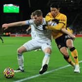 Nathan Collins of Burnley holds off Hwang Hee-chan of Wolverhampton Wanderers during the Premier League match between Wolverhampton Wanderers and Burnley at Molineux on December 01, 2021 in Wolverhampton, England.