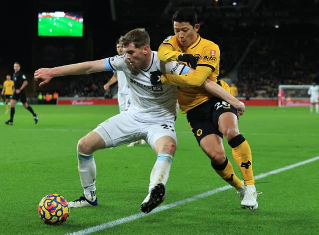 Nathan Collins of Burnley holds off Hwang Hee-chan of Wolverhampton Wanderers during the Premier League match between Wolverhampton Wanderers and Burnley at Molineux on December 01, 2021 in Wolverhampton, England.