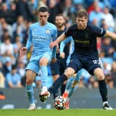 Phil Foden of Manchester City and Nathan Collins of Burnley battle for the ball during the Premier League match between Manchester City and Burnley at Etihad Stadium on October 16, 2021 in Manchester, England.