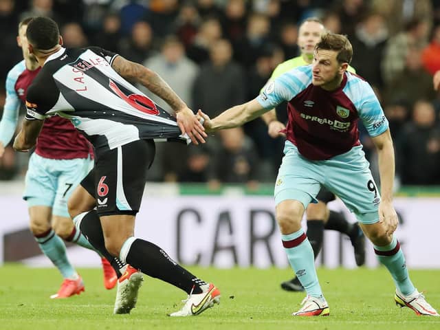 Chris Wood of Burnley pulls the shirt of Jamaal Lascelles of Newcastle United during the Premier League match between Newcastle United and Burnley at St. James Park on December 04, 2021 in Newcastle upon Tyne, England.