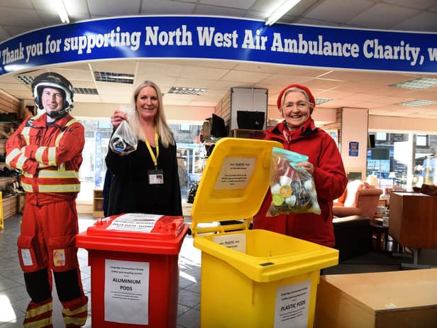 Longridge Environment Group member Margaret Baugh  recycles coffee pods watched by Jill Wright co-manager of  the North West Air Ambulance shop in Longridge  Photo: Neil Cross