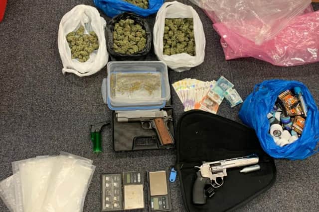 The stash of cash, drugs and guns seized by police