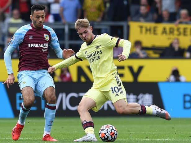 Emile Smith Rowe of Arsenal passes the ball under pressure from Dwight McNeil of Burnley during the Premier League match between Burnley and Arsenal at Turf Moor on September 18, 2021 in Burnley, England.