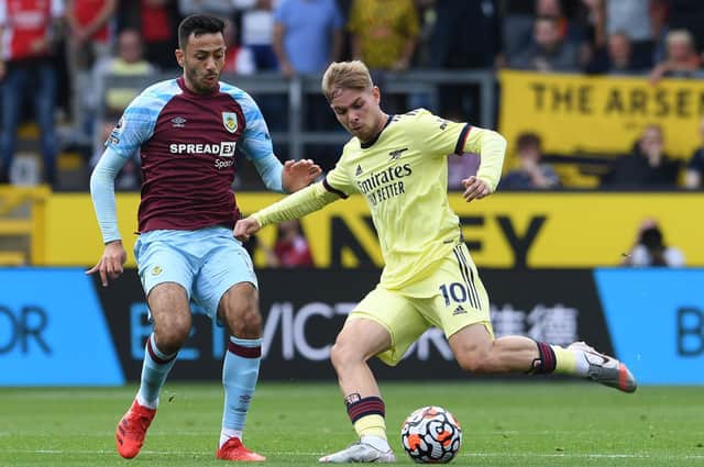 Emile Smith Rowe of Arsenal passes the ball under pressure from Dwight McNeil of Burnley during the Premier League match between Burnley and Arsenal at Turf Moor on September 18, 2021 in Burnley, England.