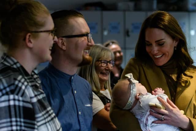 The moment the Duchess cradled baby Anastasia Barrie while her parents Trudi and Alastair look on with delight