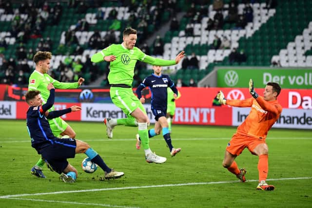 Luca Waldschmift and Wout Weghorst of VfL Wolfsburg are challenged by Niklas Stark and Alexander Schwolow of Hertha BSC during the Bundesliga match between VfL Wolfsburg and Hertha BSC at Volkswagen Arena on January 15, 2022 in Wolfsburg, Germany.