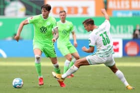 Wout Weghorst of VfL Wolfsburg is tackled by Paul Seguin of SpVgg Greuther Fürth during the Bundesliga match between SpVgg Greuther Fürth and VfL Wolfsburg at Sportpark Ronhof Thomas Sommer on September 11, 2021 in Fuerth, Germany.