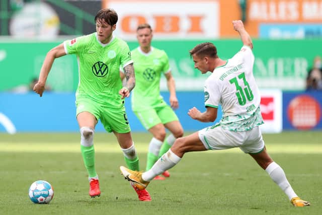 Wout Weghorst of VfL Wolfsburg is tackled by Paul Seguin of SpVgg Greuther Fürth during the Bundesliga match between SpVgg Greuther Fürth and VfL Wolfsburg at Sportpark Ronhof Thomas Sommer on September 11, 2021 in Fuerth, Germany.