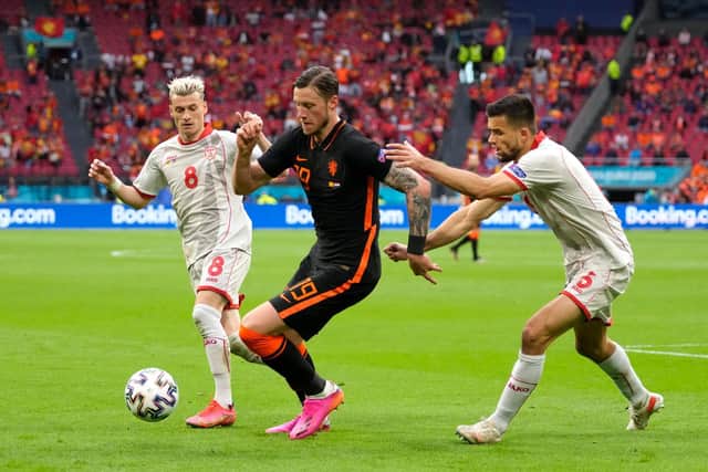 Wout Weghorst of Netherlands is challenged by Egzijan Alioski and Visar Musliu of North Macedonia during the UEFA Euro 2020 Championship Group C match between North Macedonia and The Netherlands at Johan Cruijff Arena on June 21, 2021 in Amsterdam, Netherlands.