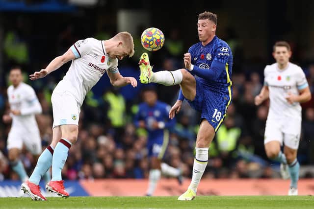 Ben Mee of Burnley competes for the ball against Ross Barkley of Chelseaduring the Premier League match between Chelsea and Burnley at Stamford Bridge on November 06, 2021 in London, England.