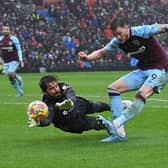 Liverpool's Brazilian goalkeeper Alisson Becker (L) saves a shot from Burnley's Dutch striker Wout Weghorst during the English Premier League football match between Burnley and Liverpool at Turf Moor in Burnley, north west England on February 13, 2022.