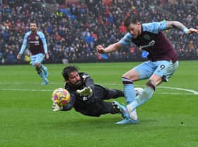 Liverpool's Brazilian goalkeeper Alisson Becker (L) saves a shot from Burnley's Dutch striker Wout Weghorst during the English Premier League football match between Burnley and Liverpool at Turf Moor in Burnley, north west England on February 13, 2022.