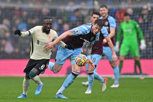 Burnley's Dutch striker Wout Weghorst (C) vies with Liverpool's Guinean midfielder Naby Keita (L) during the English Premier League football match between Burnley and Liverpool at Turf Moor in Burnley, north west England on February 13, 2022.