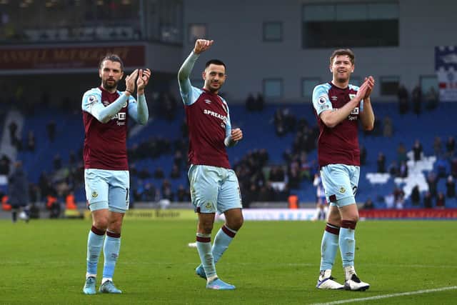 Jay Rodriguez, Dwight McNeil and Nathan Collins of Burnley acknowledge the fans following their victory in the Premier League match between Brighton & Hove Albion and Burnley at American Express Community Stadium on February 19, 2022 in Brighton, England.