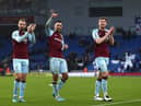Jay Rodriguez, Dwight McNeil and Nathan Collins of Burnley acknowledge the fans following their victory in the Premier League match between Brighton & Hove Albion and Burnley at American Express Community Stadium on February 19, 2022 in Brighton, England.