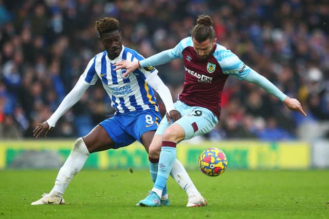 Yves Bissouma of Brighton & Hove Albion battles for possession with Jay Rodriguez of Burnley during the Premier League match between Brighton & Hove Albion and Burnley at American Express Community Stadium on February 19, 2022 in Brighton, England.