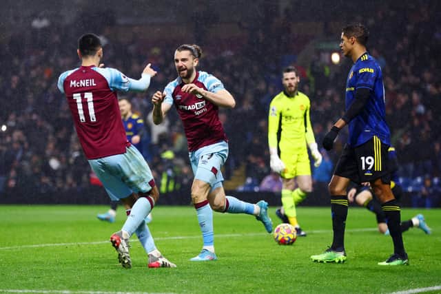 Jay Rodriguez of Burnley celebrates with teammate Dwight McNeil after scoring their team's first goal during the Premier League match between Burnley and Manchester United at Turf Moor on February 08, 2022 in Burnley, England.