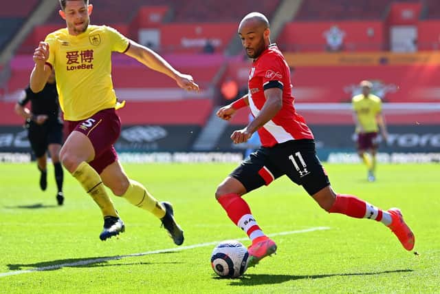 Nathan Redmond of Southampton crosses the ball under pressure from James Tarkowski of Burnley during the Premier League match between Southampton and Burnley at St Mary's Stadium on April 04, 2021 in Southampton, England.