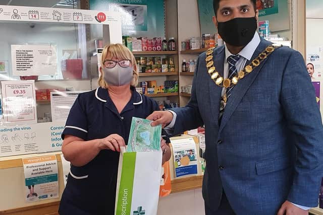 Bailey and Garrett  pharmacy technician Carole Livesey invites the Mayor to drop one of the letters into the prescription bags that will be going out to a patient