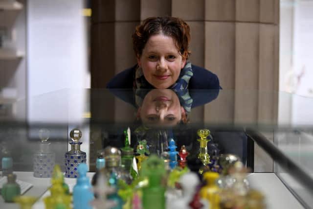 Hilary admires the Harris collection of glass which includes many perfume bottles  Photo: Neil Cross