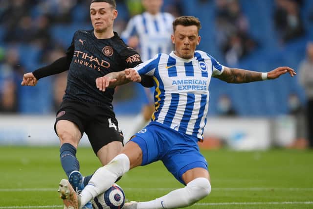 Phil Foden of Manchester City is challenged by Ben White of Brighton and Hove Albion during the Premier League match between Brighton & Hove Albion and Manchester City at American Express Community Stadium on May 18, 2021 in Brighton, England.