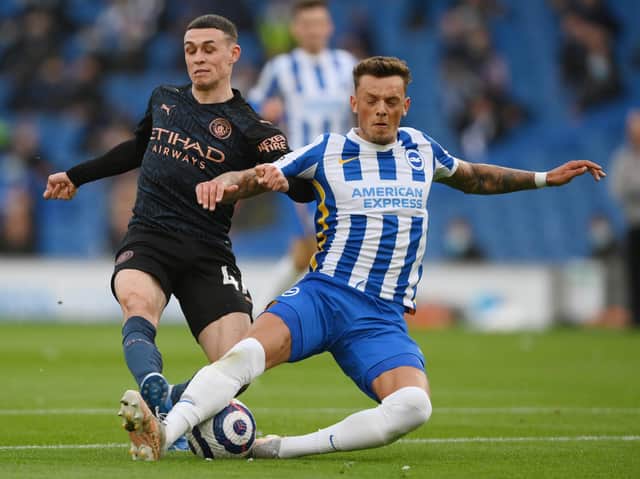 Phil Foden of Manchester City is challenged by Ben White of Brighton and Hove Albion during the Premier League match between Brighton & Hove Albion and Manchester City at American Express Community Stadium on May 18, 2021 in Brighton, England.